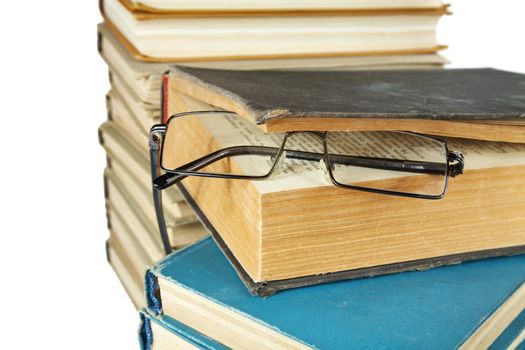 Pile of old books and glasses on a white background