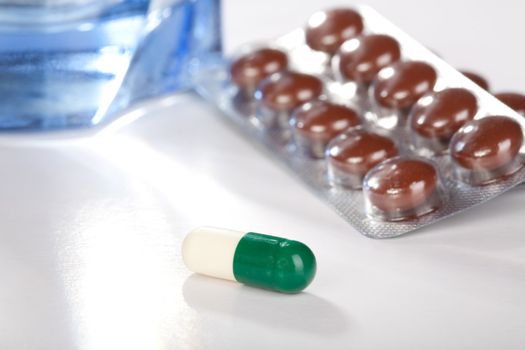 Medicines in capsules and tablets lay on a table