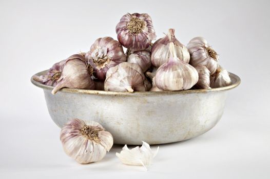 Garlic in a tin bowl on a grey background