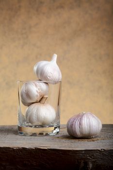 Still-life with garlic and a glass on  wooden table