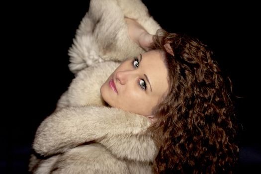 girl in a fur coat on a black background