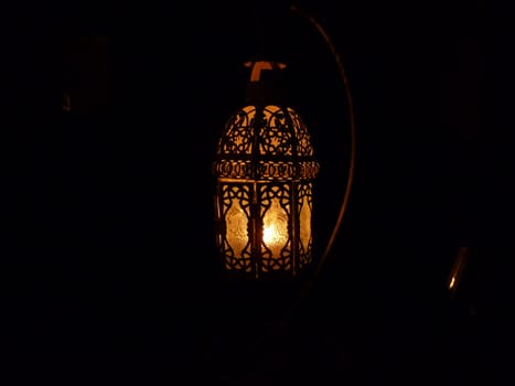 candle illuminated moroccan lantern in the dark