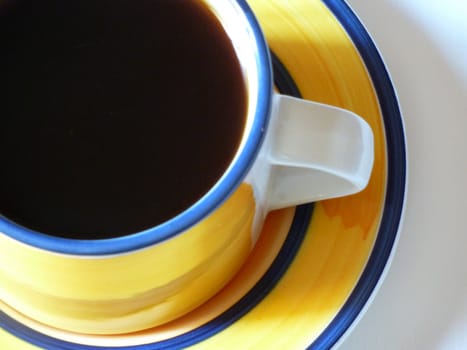 fresh black coffee in yellow coloured cup