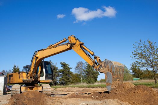 excavator working on a construction site on a sunny summer day