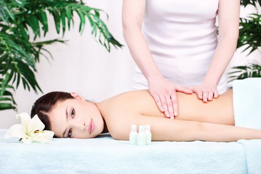 Pretty woman on back massage in spa center