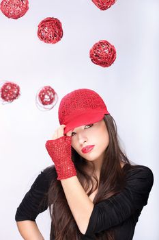 Pretty woman with red hat between red balls