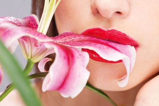 Close up of a pretty woman's lips and oriental flower