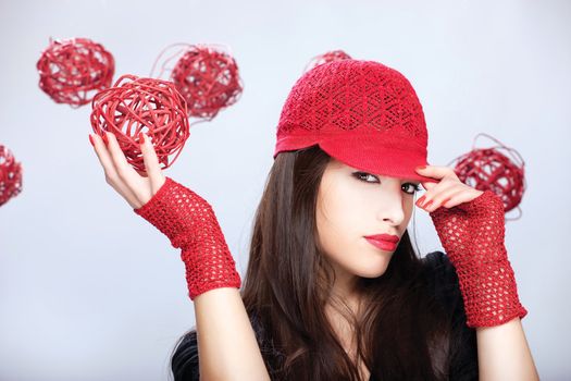 Pretty woman with red hat holding red ball