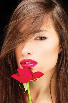 Pretty woman and red rose near her lips