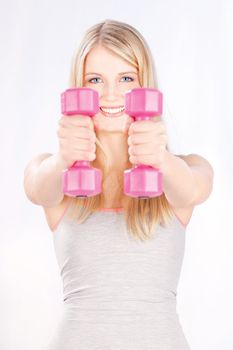 Young woman with two weights doing fitness exercises