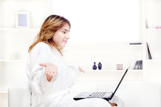 teenage girl at home in bathrobe chatting on computer