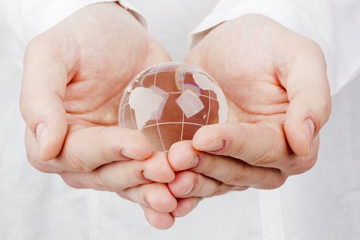 Close-up photograph of a glass globe in a man's hands.
