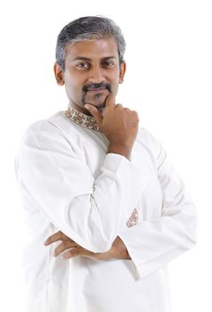 Confident mature traditional Indian man in kurta dhoti isolated on white background