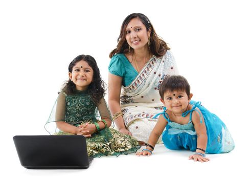 Traditional Asian Indian family using laptop computer over white background