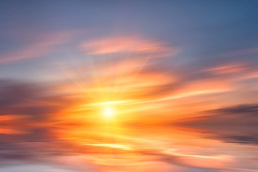 Beautiful sunset over sea with reflection in water, colorful clouds in the sky