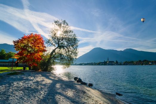 Beautiful morning on lake with mountains on background and baloon in the sky