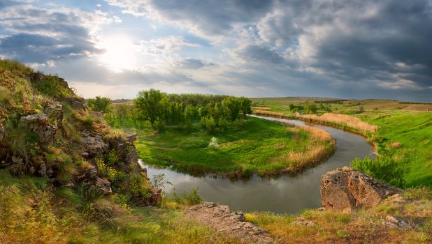 View from the mountain on the river, the wood and a meadow, shined with a bright sun