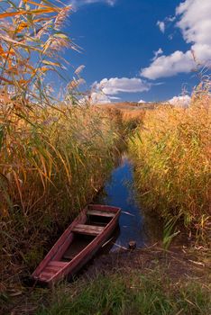 The lonely boat on the river, autumn landscape