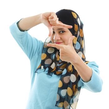Smiling Asian Muslim woman making a frame with fingers
