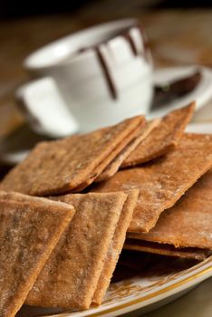 Assorted cookies in  plate and white mug of chocolate. Small depth of field