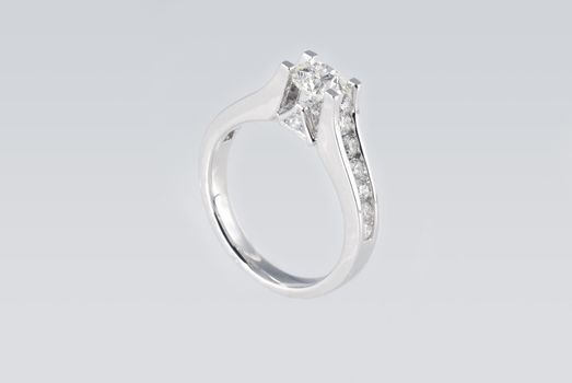 Platinum ring with diamonds over white background