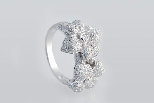 Platinum ring with diamonds over white background