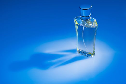 Close up of perfume bottle on blue background
