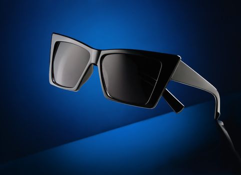Closeup trendy sunglasses on the dark blue abstract background