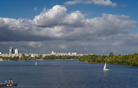 Sailing boat on the river with sityscape on background