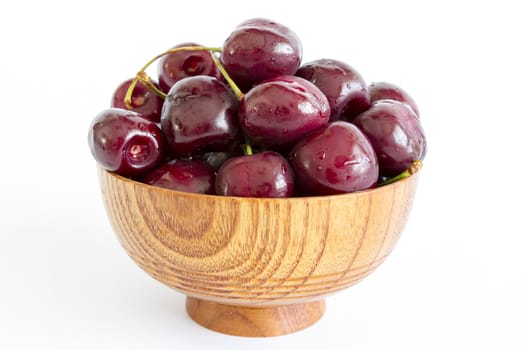 Cherry in wooden bowl isolated on white background