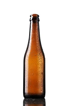 Empty bottle of beer with drops isolated on white background.