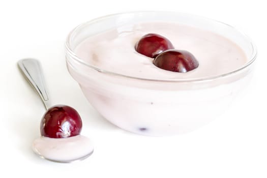 Glass bowl with cherries yoghurt,  spoon with cherries and yogurt.