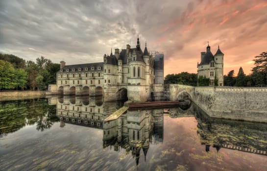 wide dark scene of Chenonceau Castle, France at sunset