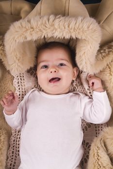 Close up view of a newborn baby inside a winter jacket.