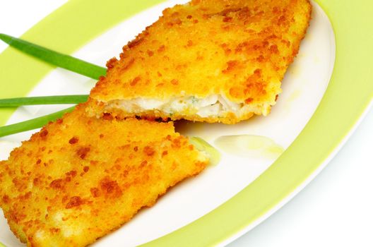 Breaded Сod Fillet with Spring Onion on Green Plate closeup