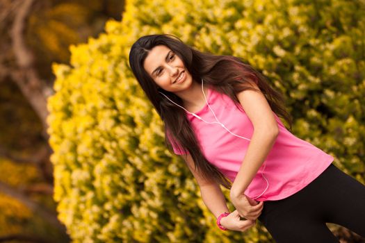 Young beautiful woman with sporty look enjoying with headphones outdoors