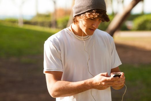 young handsome man consulting phone outdoors