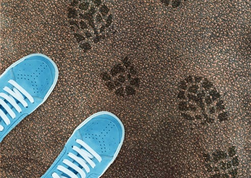 Blue sport shoe on street and shoes print around.