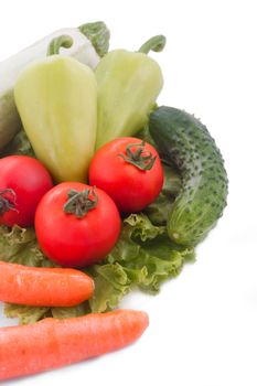 Carrots, peppers, cucumbers and greens on white