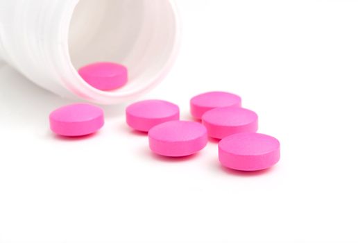 Pink Pills in White Bottle On White Background