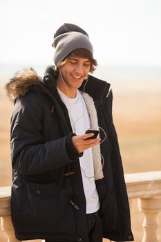 young handsome man consulting phone outdoors