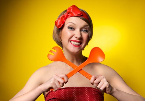 Beautiful pinup style housewife with kitchen utensils