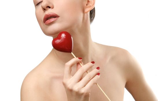 Beautiful woman holding red heart. Face closeup. Isolated on white background