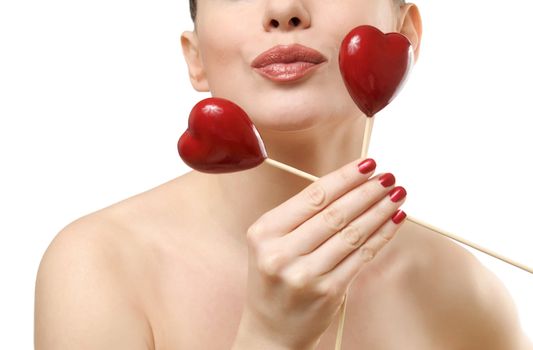 Beautiful woman holding two red hearts. Face closeup kissing. Isolated on white background