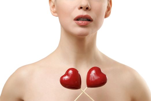 Beautiful woman holding two red hearts crossed. Face closeup. Isolated on white background