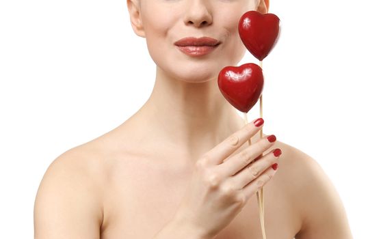 Beautiful woman holding two red hearts. Face closeup. Isolated on white background