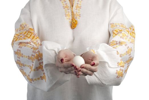 Woman's hands holding the egg. Traditional Ukrainian dress. Isolated on white