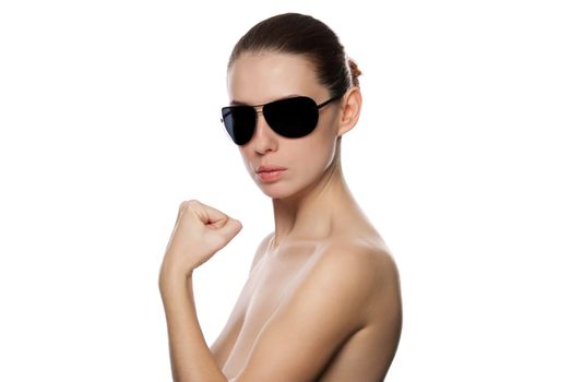 Portrait of glamour woman in sunglasses shows a fist. Isolated on white background