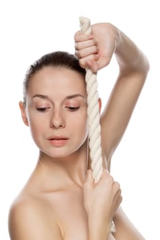 Portrait of young beautiful woman with a thick rope. Isolated on white background