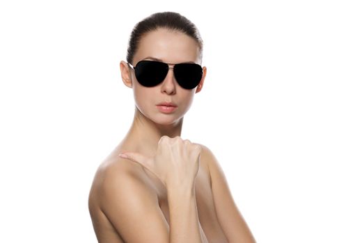 Portrait of glamour woman in sunglasses shows the rigth. Isolated on white background